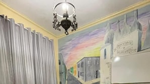 Un salón de conferencias con una mesa de madera, sillas negras, una pizarra y un mural en la pared.