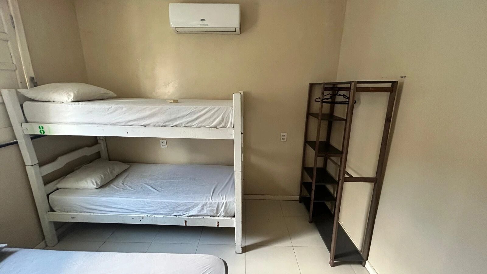 Una cama litera con una estantería a su lado.