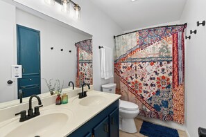 Ein Badezimmer mit Waschbecken, Toilette und Duschvorhang mit Blumenmuster.