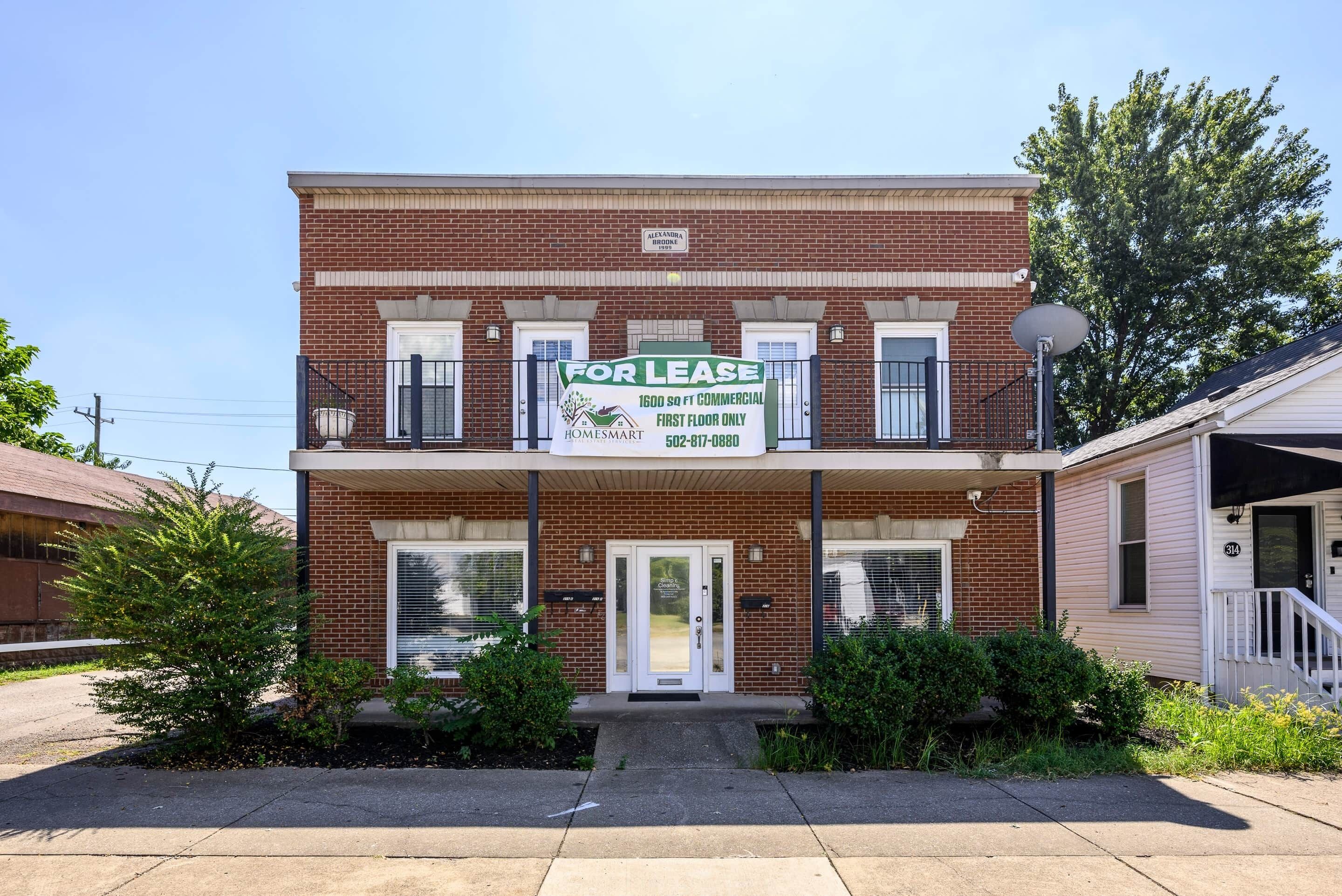 A two-story building with a 'For Lease' sign, a 'Homesmart' logo, and a 'Simple Clean' sign.