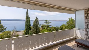 Uma varanda com vista para um lago e árvores.