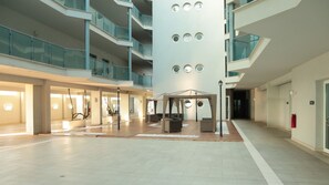 A spacious indoor atrium with a central column, multiple balconies, and a covered seating area. - Flamingo Sunset Cruise (ROMA)