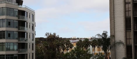 Un edificio moderno con varios balcones y una vista despejada de un avión en el cielo.