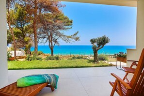 Un patio con muebles de madera y vista al mar.