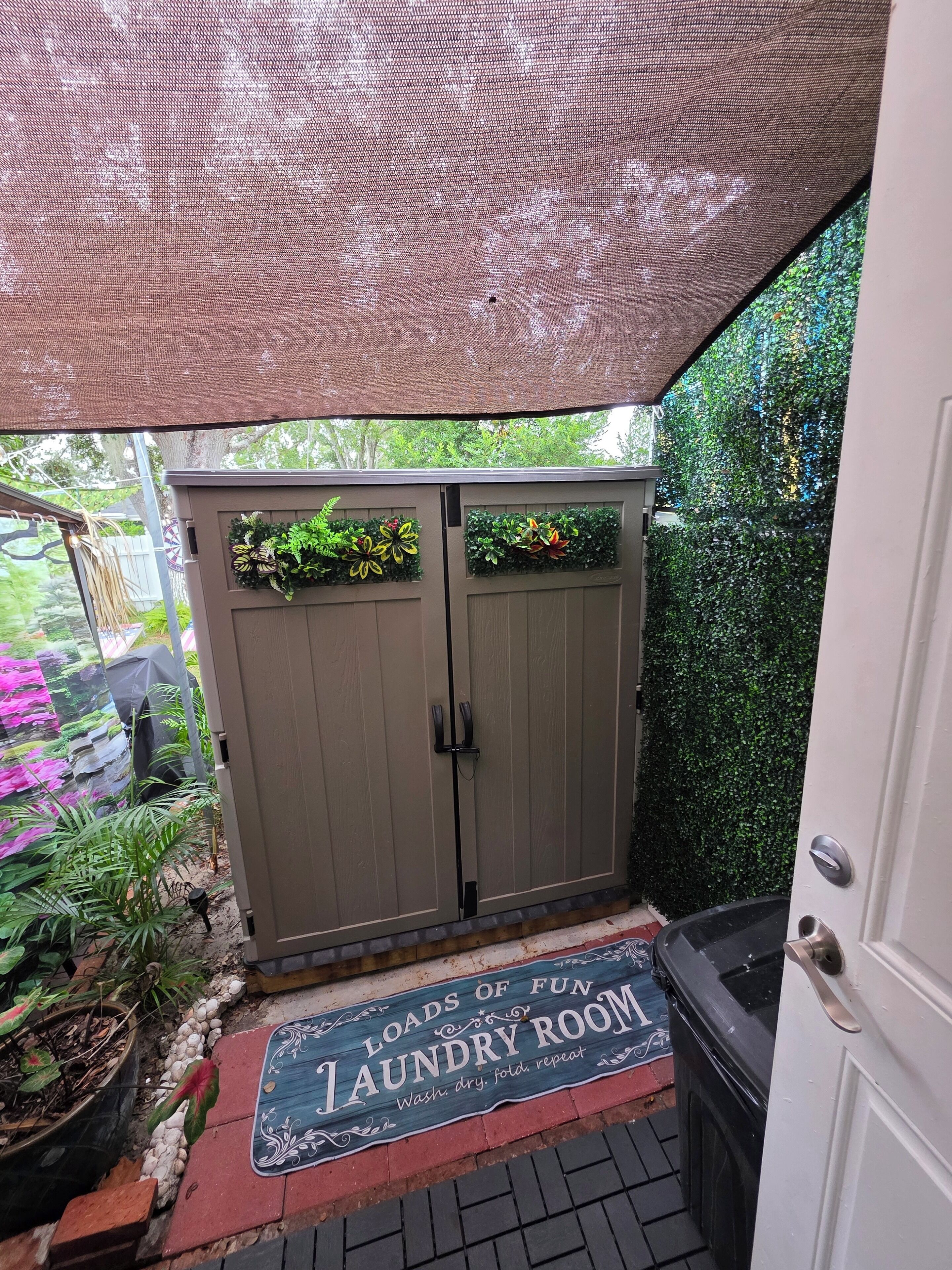 A laundry room with a sign reading "Loads of Fun Laundry Room" and a mat that says "Wash, dry, fold, repeat."