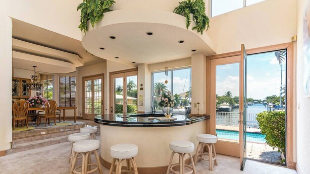 A spacious kitchen with a central island, large windows, and a view of the pool and marina. - Spacious house walking distance to the beach (Lauderdale-by-the-Sea)