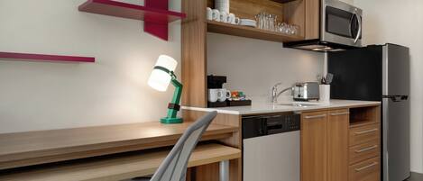 A modern kitchen with wooden cabinets, a stainless steel refrigerator, a microwave, and a dishwasher.