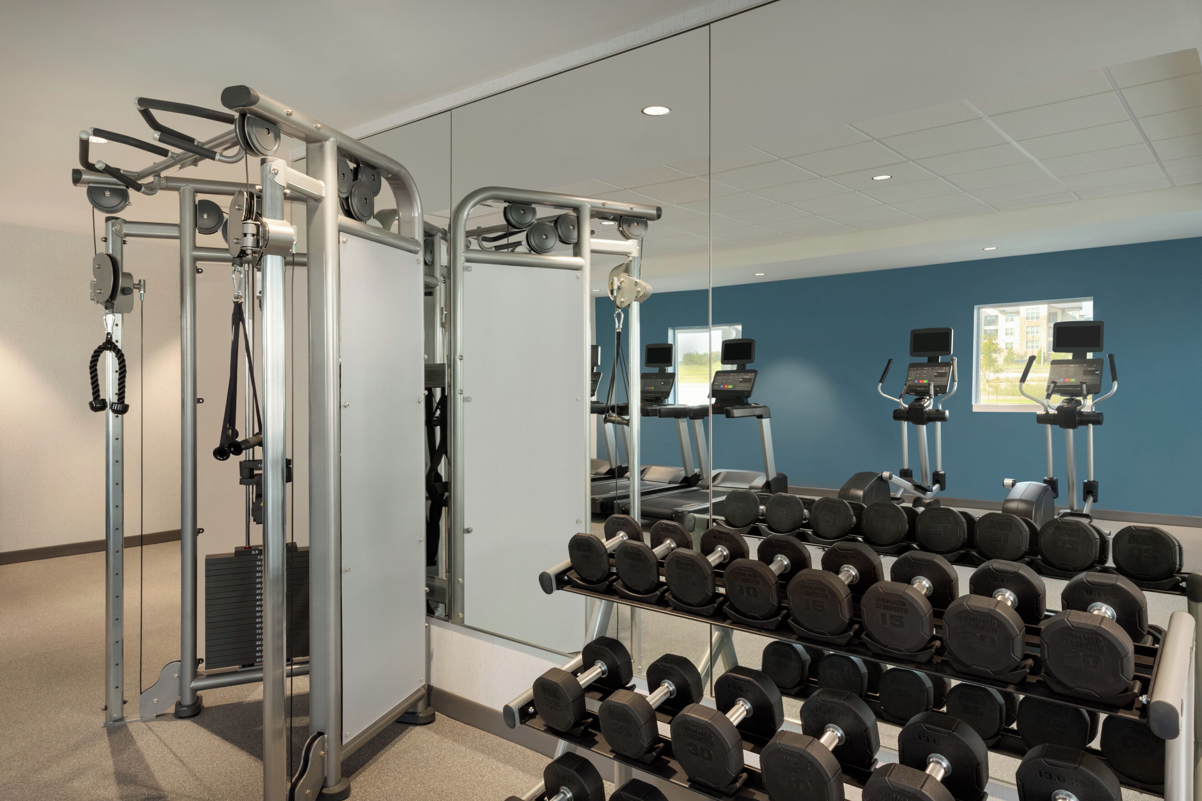 Une salle de sport équipée de matériel de musculation et d’haltères.