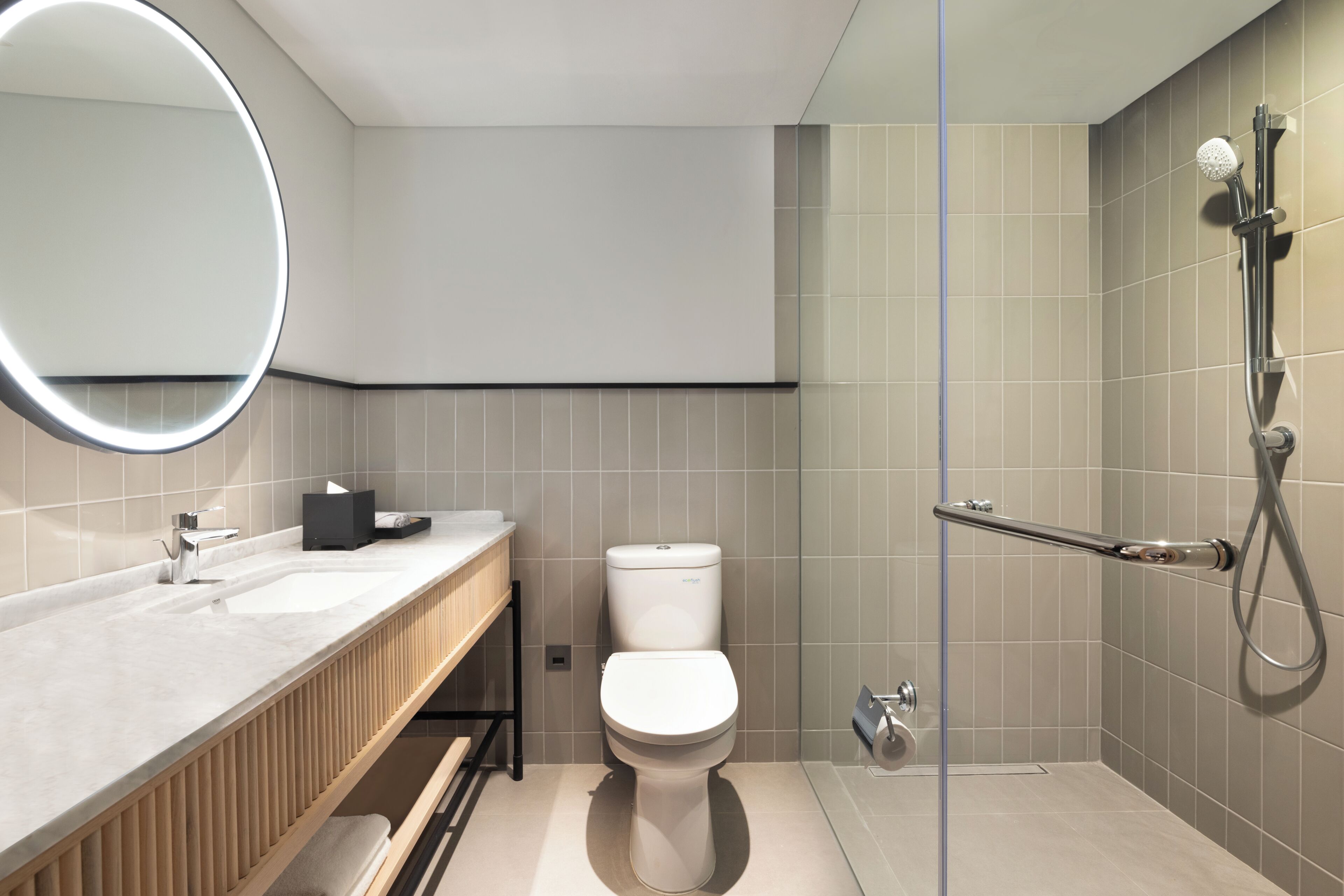 A modern bathroom with a toilet, sink, and shower.