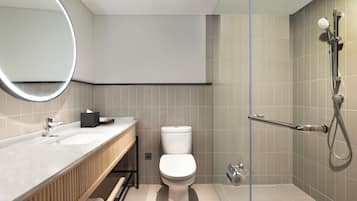 Un baño moderno con inodoro, lavamanos y ducha.