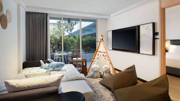 Ein modernes Hotelzimmer mit einem Bett, einer Couch, einem kleinen Tisch, einem Zelt und einem Fernseher.