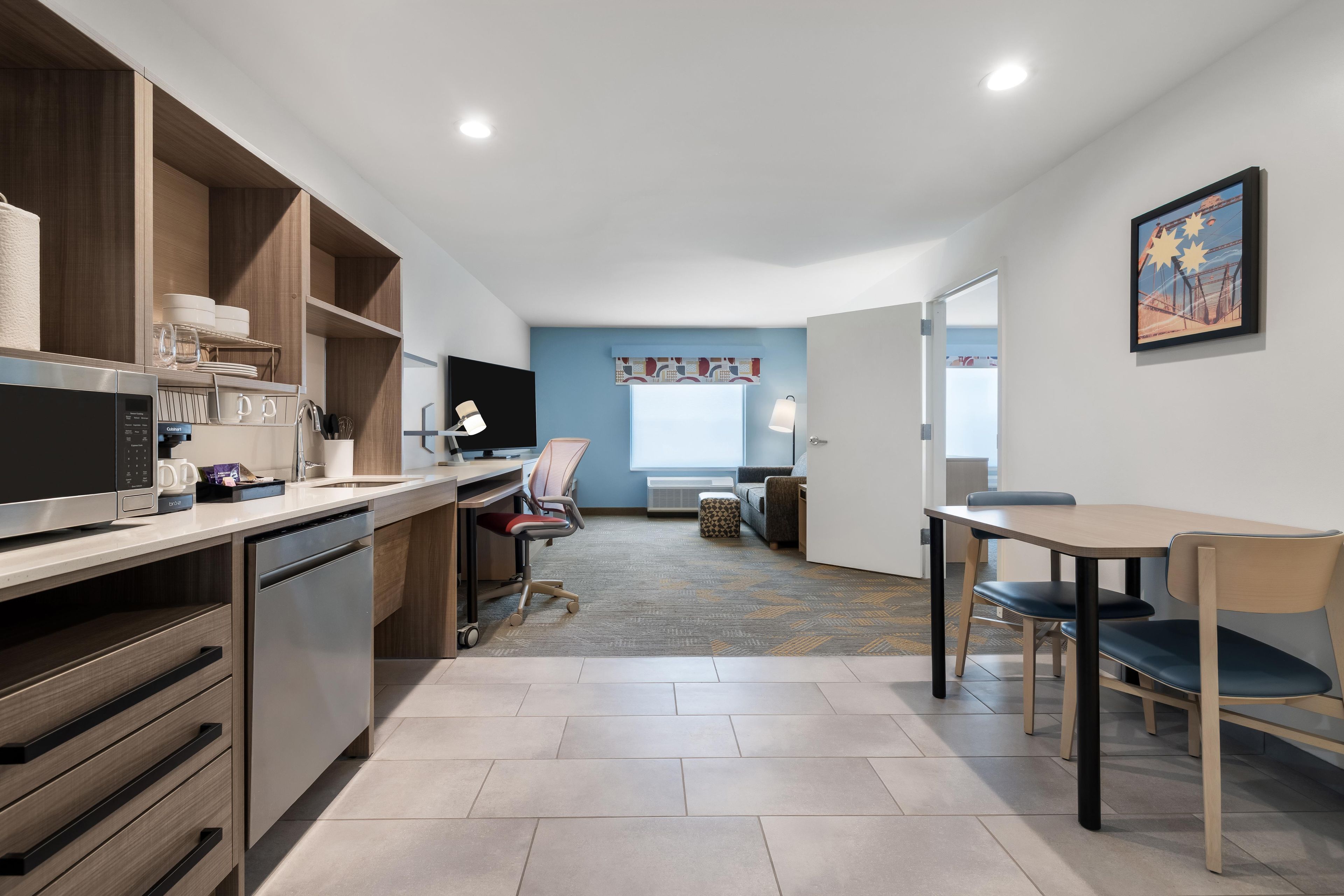 A modern kitchen with a built-in dishwasher, a microwave, and a coffee machine.
