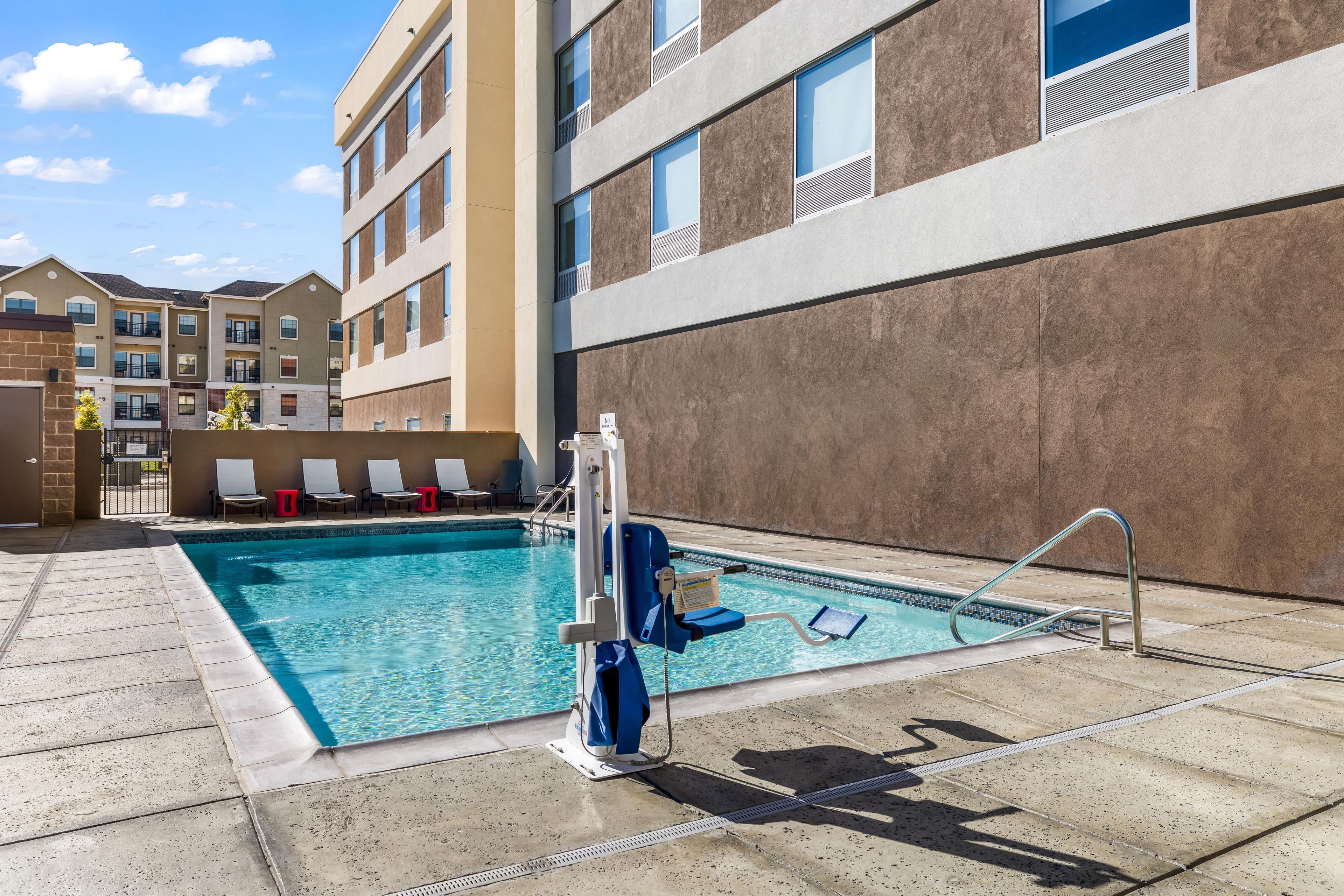 Ein Swimmingpool mit Wasserrutsche, Liegestühlen und einer Poolanlage.