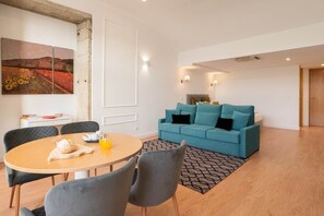 Una sala de estar moderna con una mesa redonda, dos sofás y un cuadro en la pared.