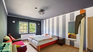Un dormitorio con cama, una silla, una mesita de noche, un espejo y una ventana.