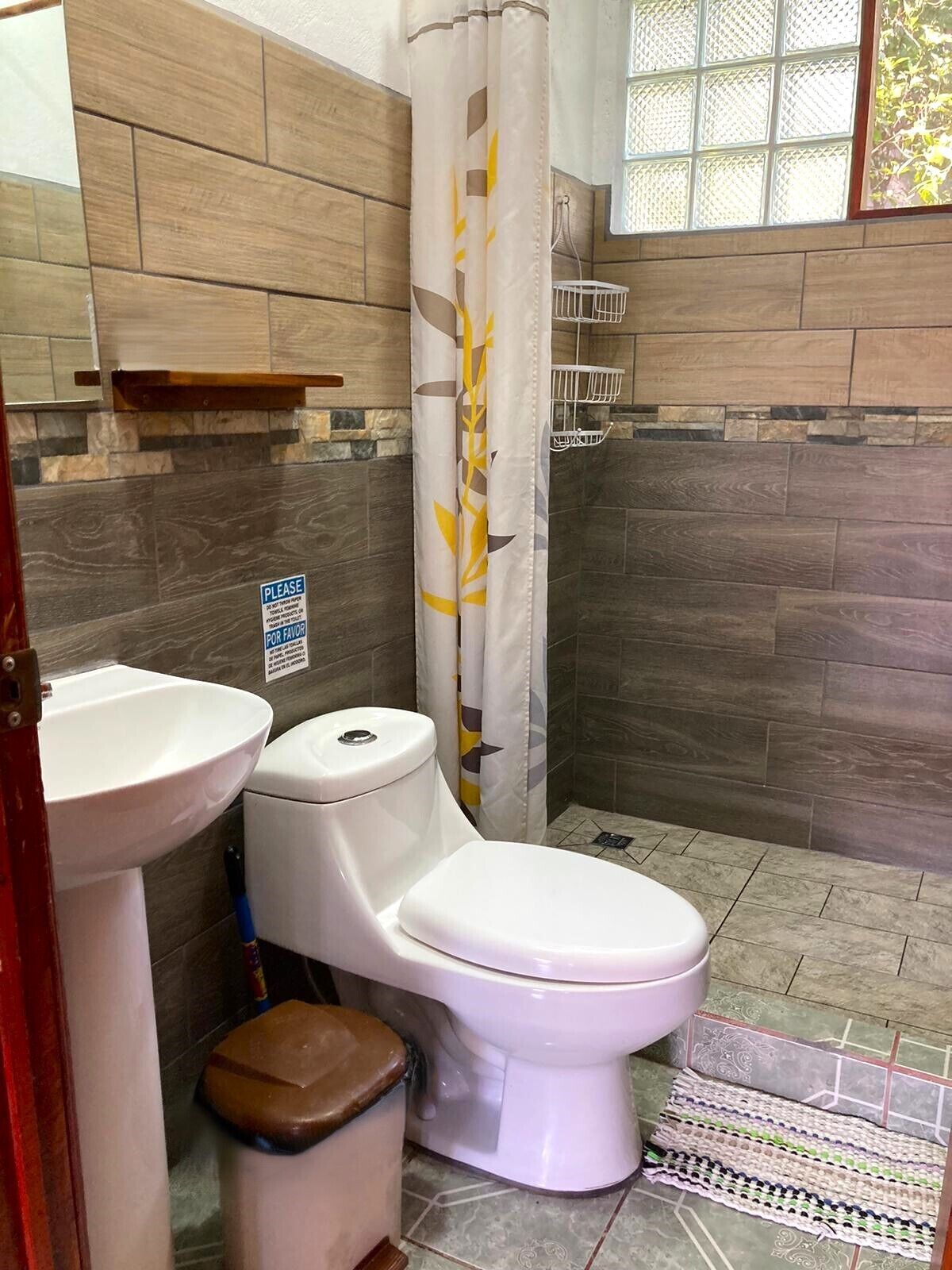 A bathroom with a toilet, sink, and shower curtain.