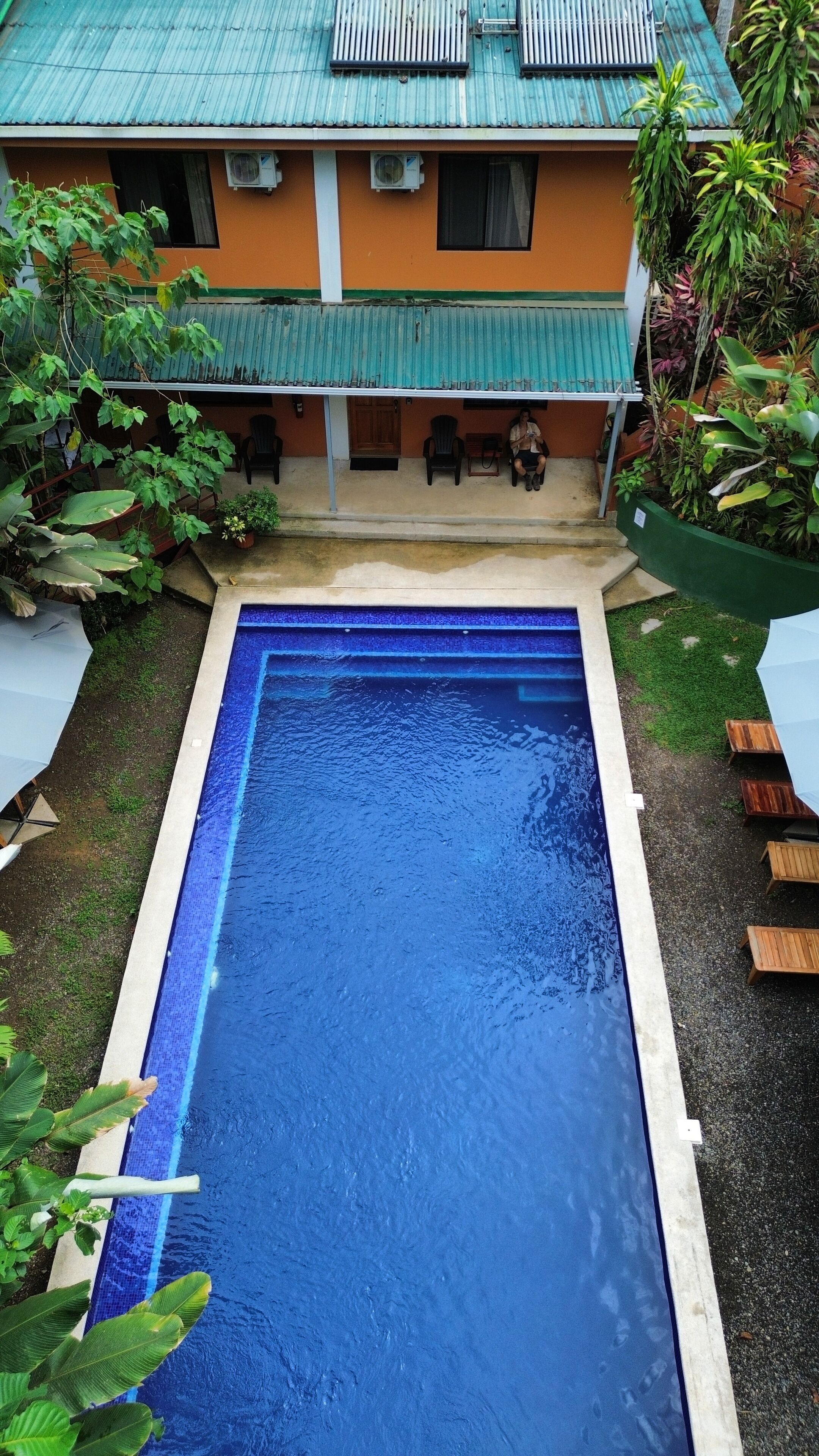 A rectangular swimming pool with a blue interior, surrounded by a concrete deck.