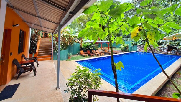 A covered outdoor area with a swimming pool, wooden deck, and seating area. - CORCOVADO & DRAKE INN (Drake Bay)