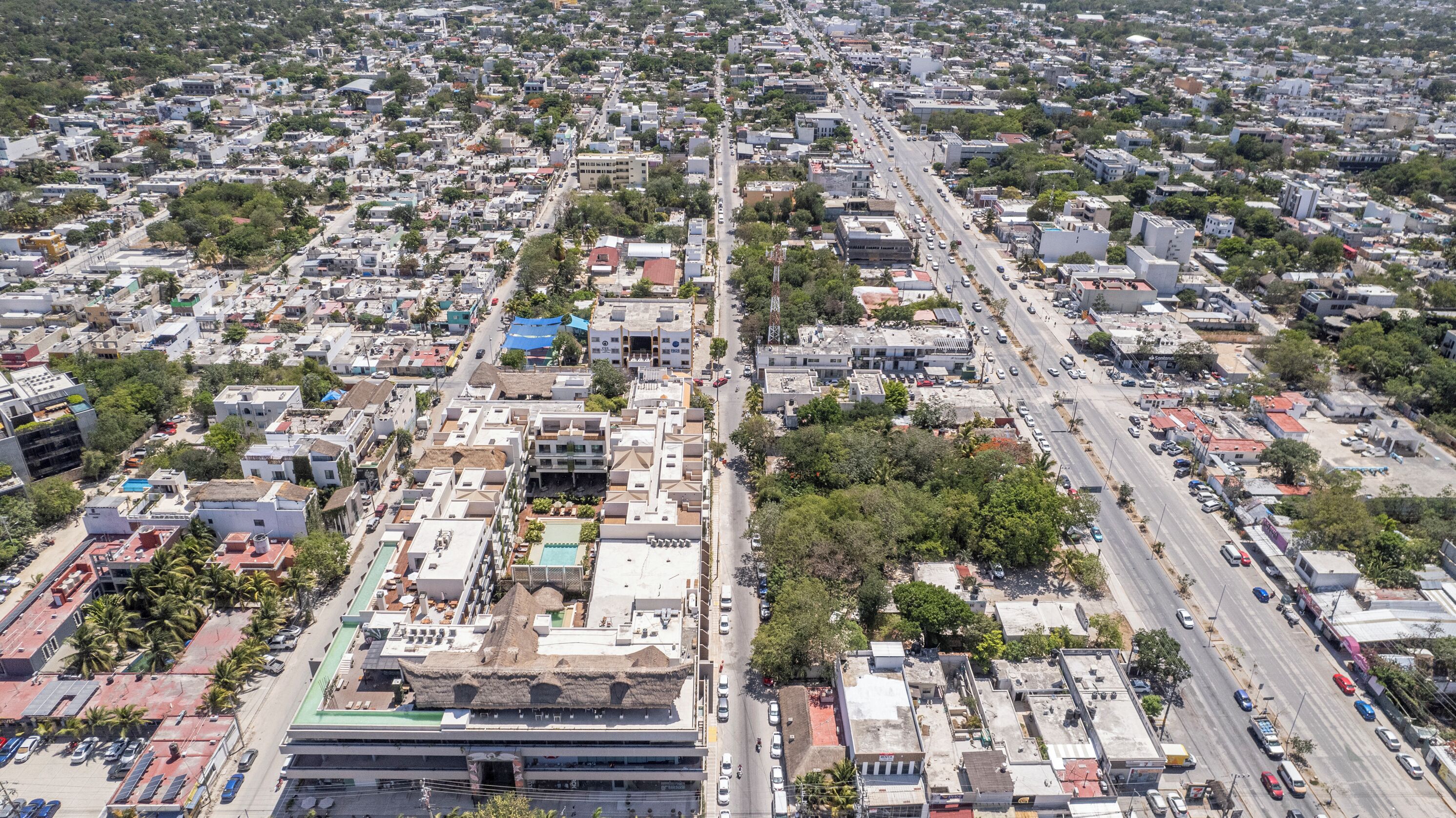 An aerial view of a densely populated urban area with a mix of residential and commercial buildings, wide streets, and visible traffic.