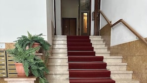 Eine Treppe mit roten Teppichstufen führt zu einer Tür oben.