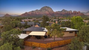 A residential area with houses, a covered patio, and a mountain backdrop.