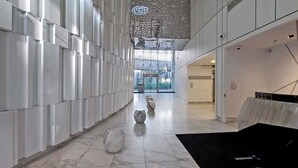 A modern interior with a long corridor, white walls, and a patterned ceiling. - Modern Waterfront 3BR Escape with Free Parking (Toronto)