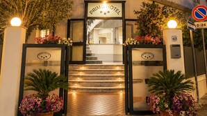 A hotel entrance with a sign reading 'PRIMO HOTEL,' a staircase leading inside, and a no parking sign. - Primo Hotel (Marciana Marina)