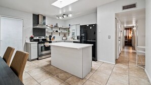 A modern kitchen with a central island, built-in appliances, and a skylight. - 3-bedroom house in beautiful Tucson with WiFi, AC (Tucson)