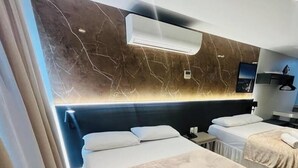 Une chambre d’hôtel avec deux lits, un mur en marbre et un système de climatisation moderne.