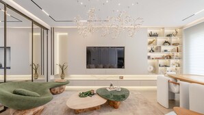Ein modernes Wohnzimmer mit einer Couch, einem Couchtisch und einem Fernseher.