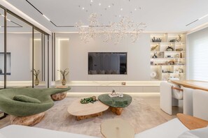 A modern living room with a sofa, coffee table, and TV. - Luxury Villa with Pool and Garden 4BR The Springs (Dubai)