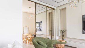 Ein modernes Wohnzimmer mit einem grünen Sessel, einem Holztisch und einem Essbereich mit Holzsesseln und einem Tisch.
