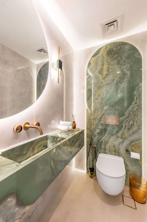 A modern bathroom with a marble vanity, a white toilet, and a glass sink. - Luxury Villa with Pool and Garden 4BR The Springs (Dubai)