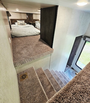 Un dormitorio con una cama litera, un escritorio pequeño y una ventana.