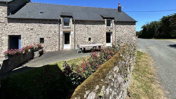 A stone building with a sloped roof, a small balcony, and a table with chairs outside. - Family house with terrace in Fréhel | 8 guests | Ref 301 (FREHEL)