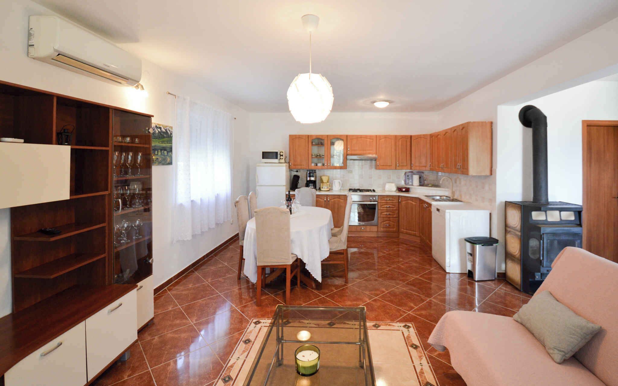 A modern kitchen with wooden cabinets, a dining area with a table and chairs, and a living room with a sofa and a coffee table.