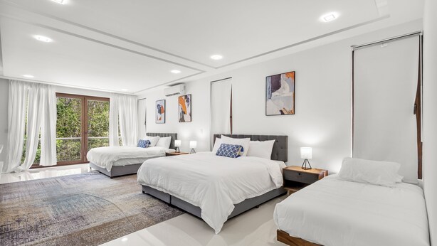 A modern hotel room with two beds, a large window with curtains, a view of greenery, and artwork on the walls. - Senderos De Ciudad Mayakoba (Playa del Carmen)