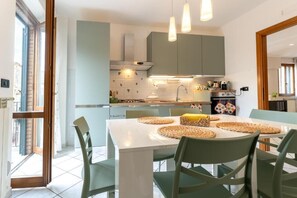 A modern kitchen with a white countertop, green chairs, and pendant lights. - Holiday House “La Terrazza HOUSE” in the heart of Lanciano (Lanciano)