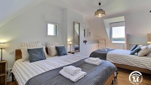 A modern hotel room with two beds, a large window, and a view of the sea. - Ty Bayon - BELZ - Gîte (BELZ)