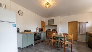 Una cocina compacta con una isla central, horno integrado y microondas.