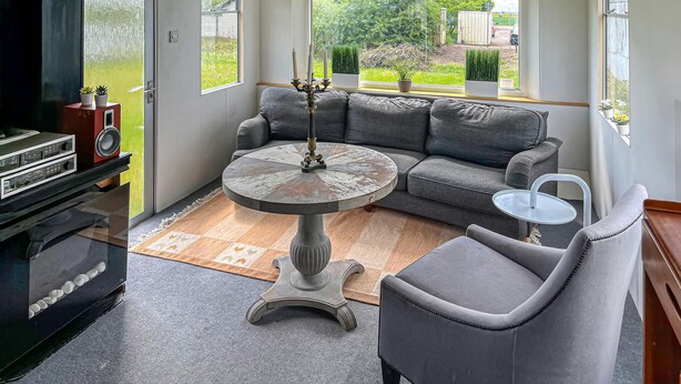 Un salon moderne avec un canapé gris, une table basse ronde et une cheminée.