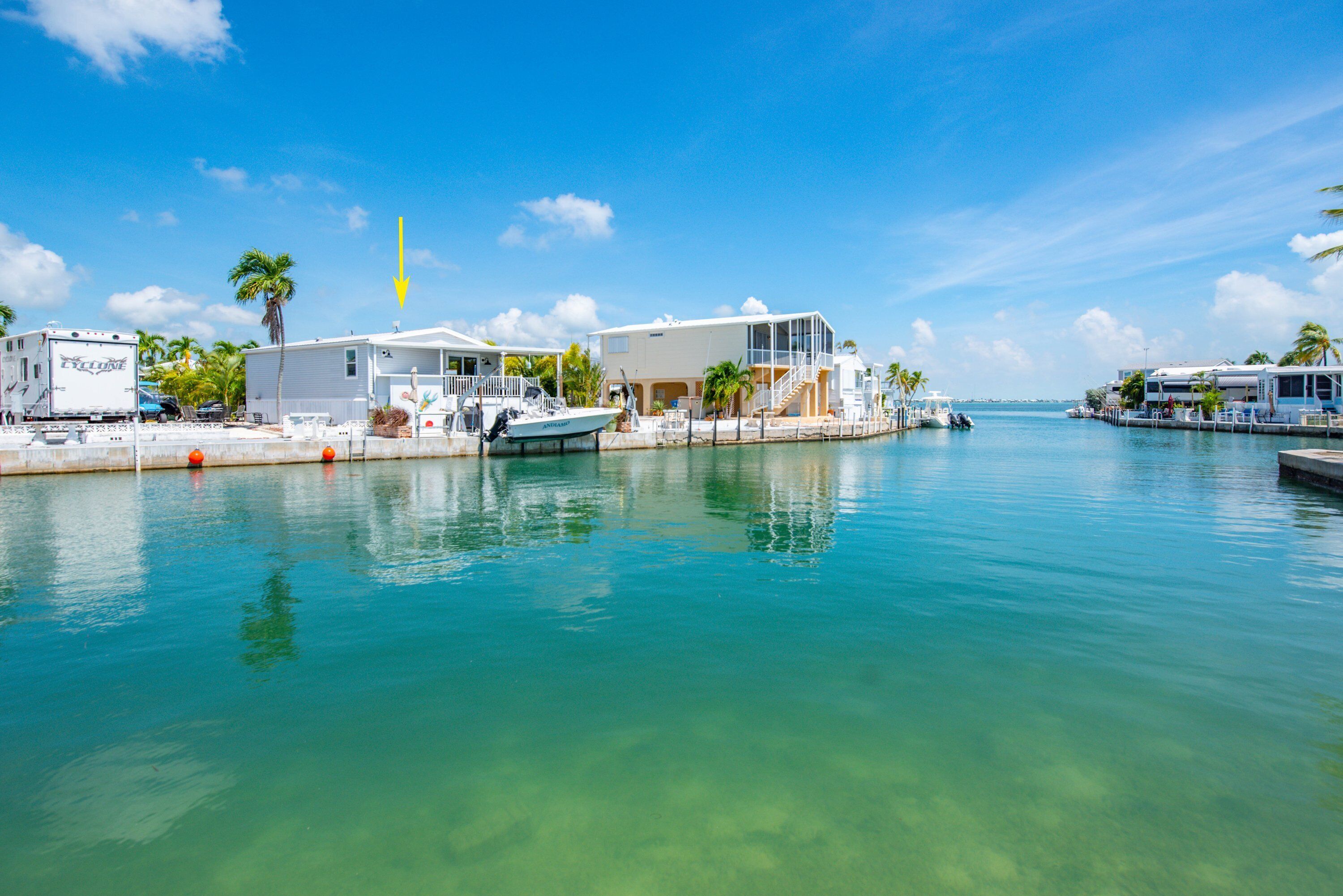 A waterfront property with a marina, a boat docked, and a building with a balcony overlooking the water.