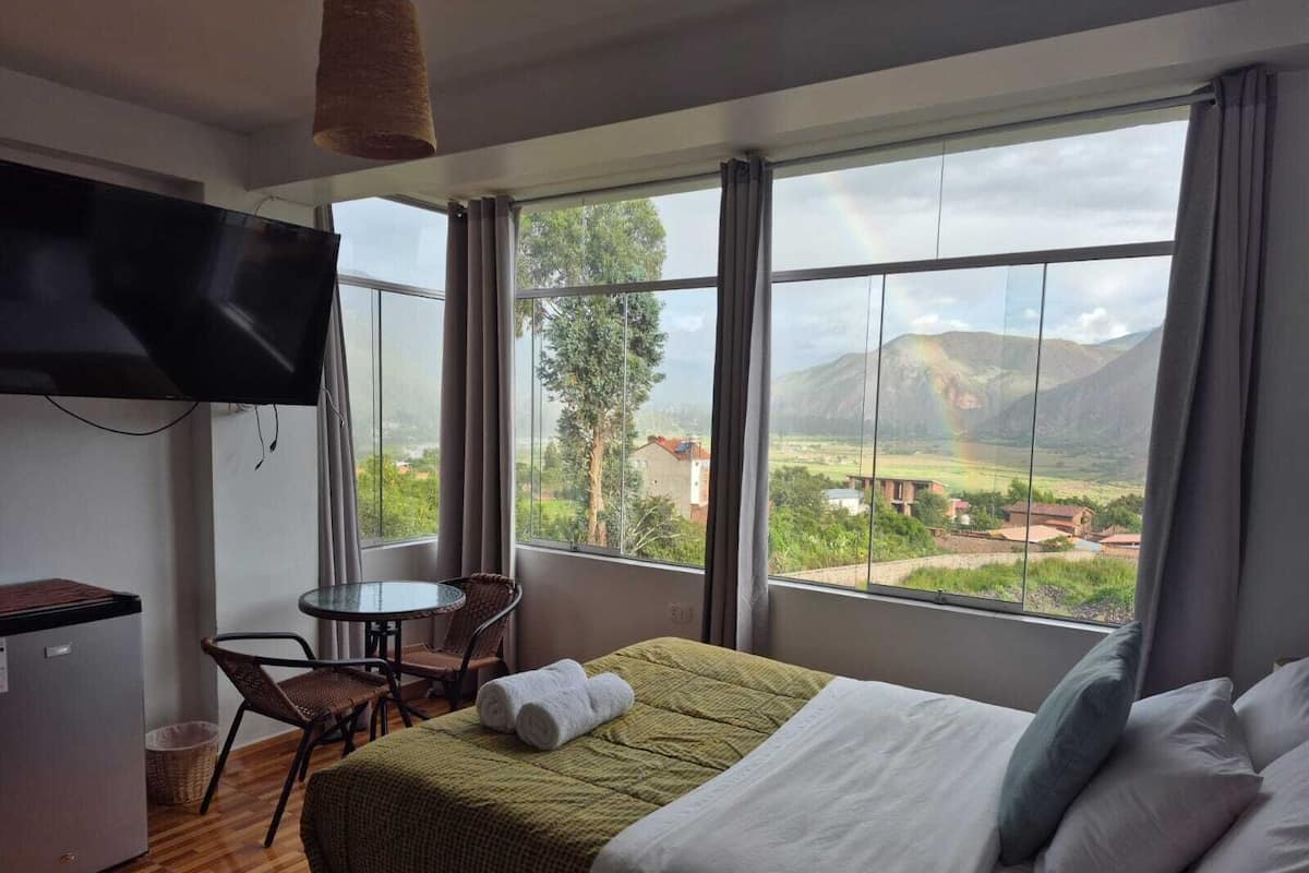 Una habitació d'hotel amb un llit, una taula de treball, una cadira i una televisi ó.