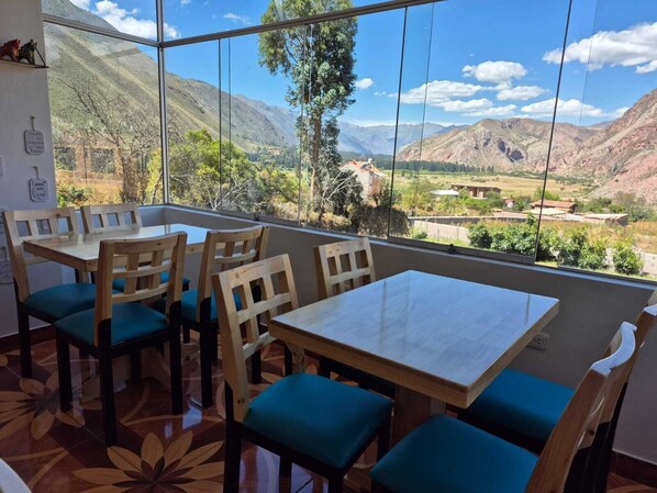 A dining area with a large window offering a mountain view. - CASA YANAHUARA URUBAMBA (Urubamba)