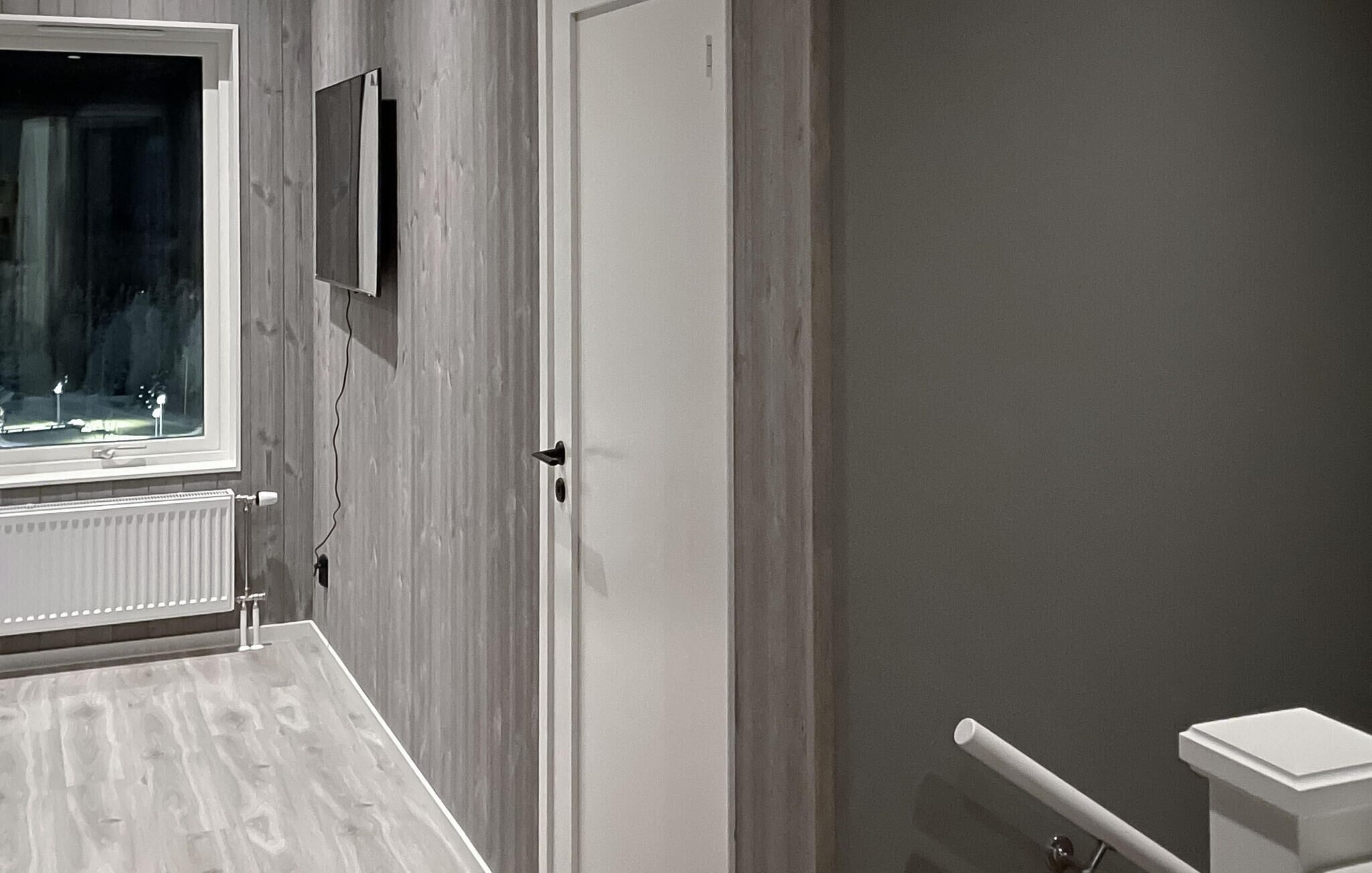 A bathroom with a white vanity, a radiator, a door, and a towel rack.