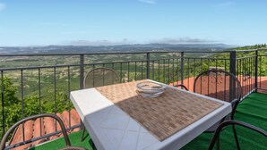 Une terrasse avec une table et des chaises, offrant une vue sur un paysage magnifique.