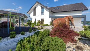Ein modernes Haus mit einer großen Elefantenskulptur im Garten.