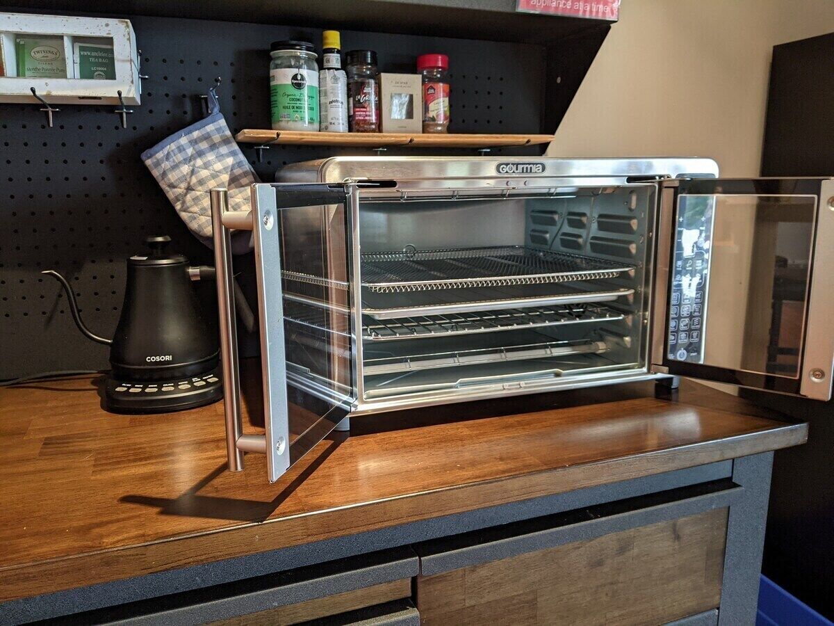 Eine Küche mit Backofen, Kaffeemaschine und Gewürzregal.