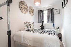 A bedroom with a bed, a standing lamp, a nightstand, and a wall-mounted artwork. - Beverley Central Quiet 3 bedroom Homey Parking (East Riding of Yorkshire)