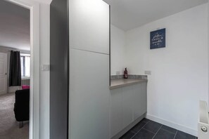 A modern kitchen with a built-in oven, a small countertop, and a wall-mounted light.
